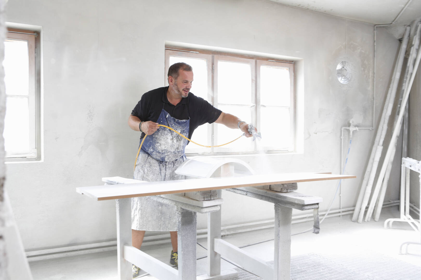 Man spray painting timber